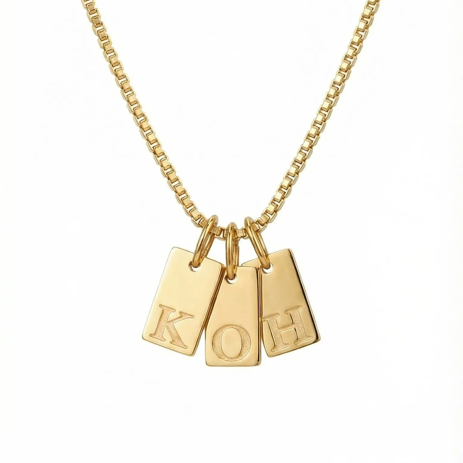 Gold necklace with three pendant tags on a white background