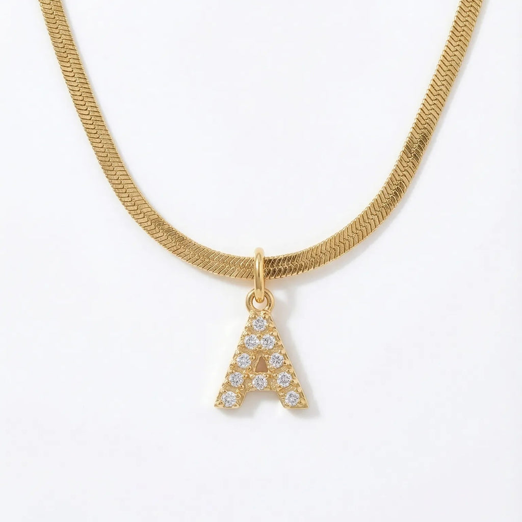 Gold necklace with a diamond-studded letter 'A' pendant on a white background