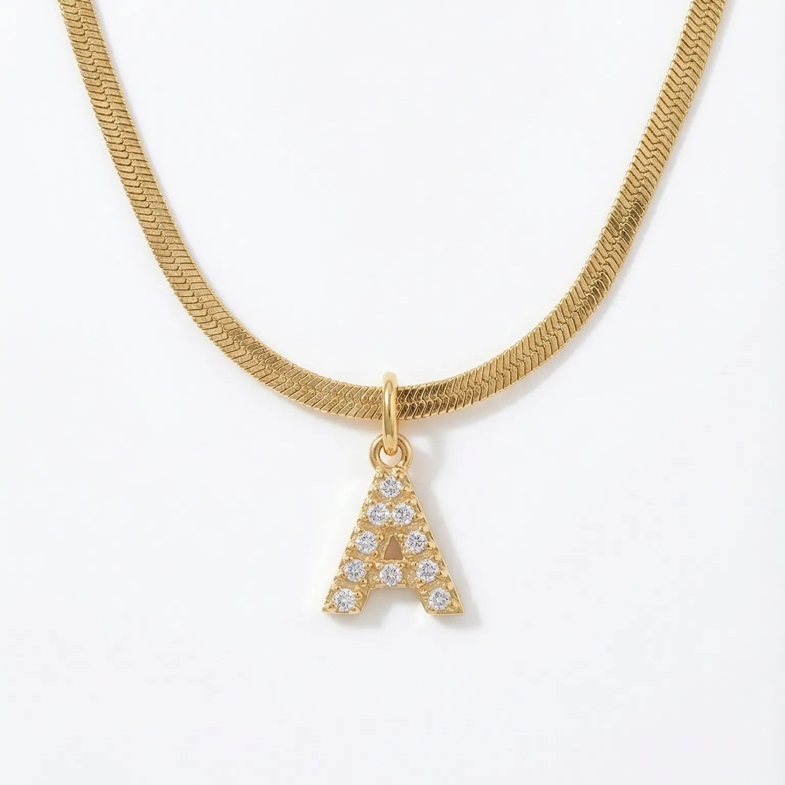 Gold necklace with a diamond-studded letter 'A' pendant on a white background