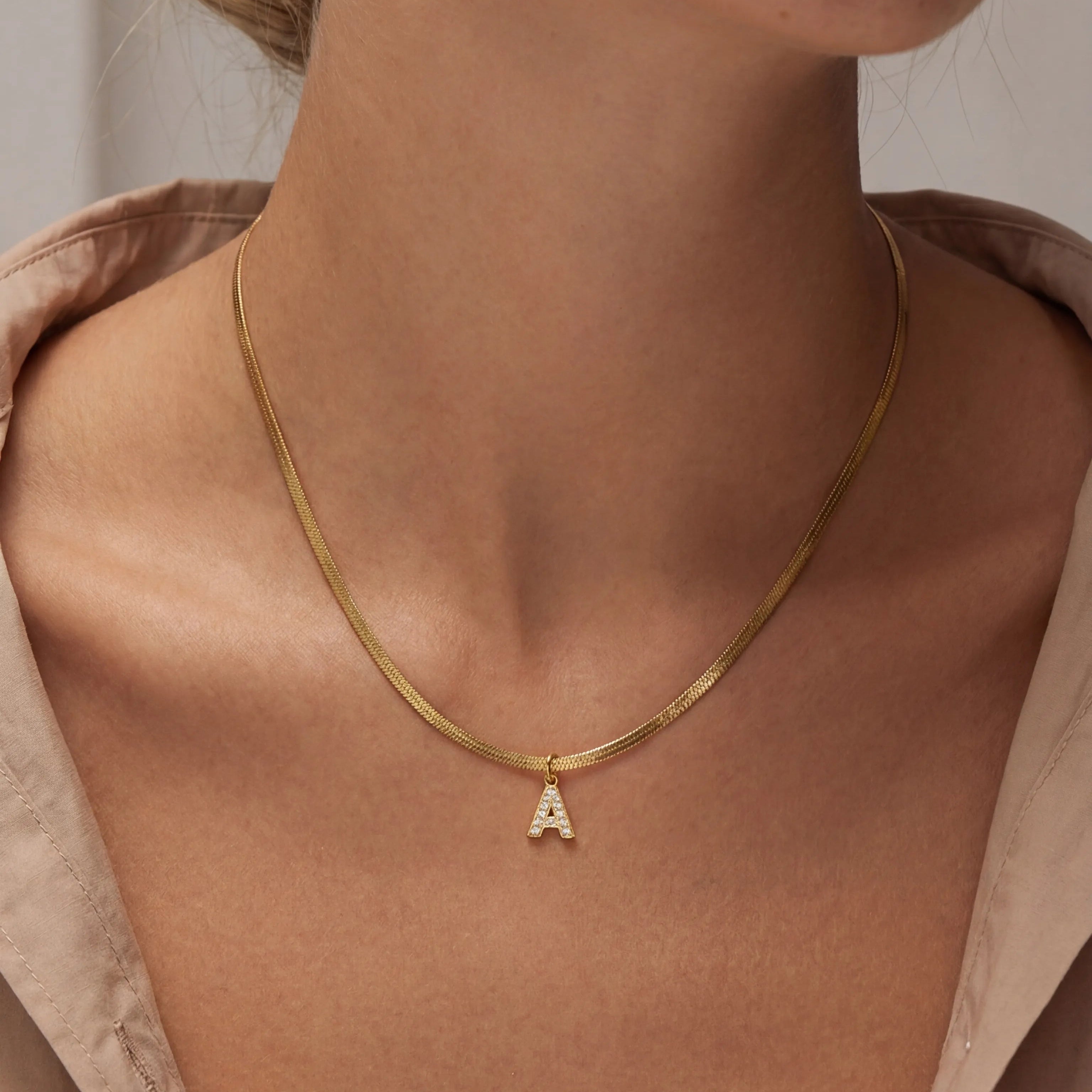 Gold necklace with a small pendant worn by a model